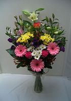 Bouquet classique paste composé de lys longiflorum, gerberas roses, décos jaunes, alstromeria blancs, lysianthus, roses