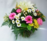 Bouquet rond pastel composé de lys blancs, germinis roses, santinis blancs, santinis jaunes, roses roses, fougère américaine, salal