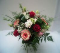 Bouquet rond rouge et rose composé de roses rouges, germinis roses, gypsophile, feuilles d'aspedistra, de fougère et d'asparagus